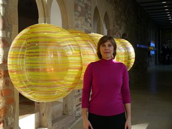 Gaby Peters steht vor Ihrer Arbeit "Newtons Wiege" im Stadtmuseum Simeonstift Trier